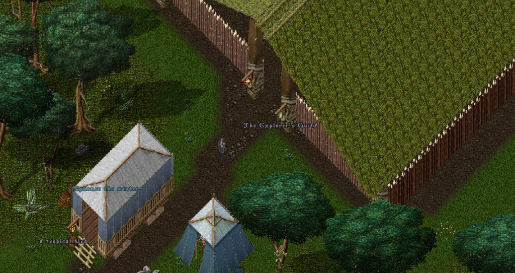 A wooden structure with a grassy roof. There are tents outside
